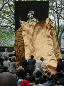 People unveiling an artwork